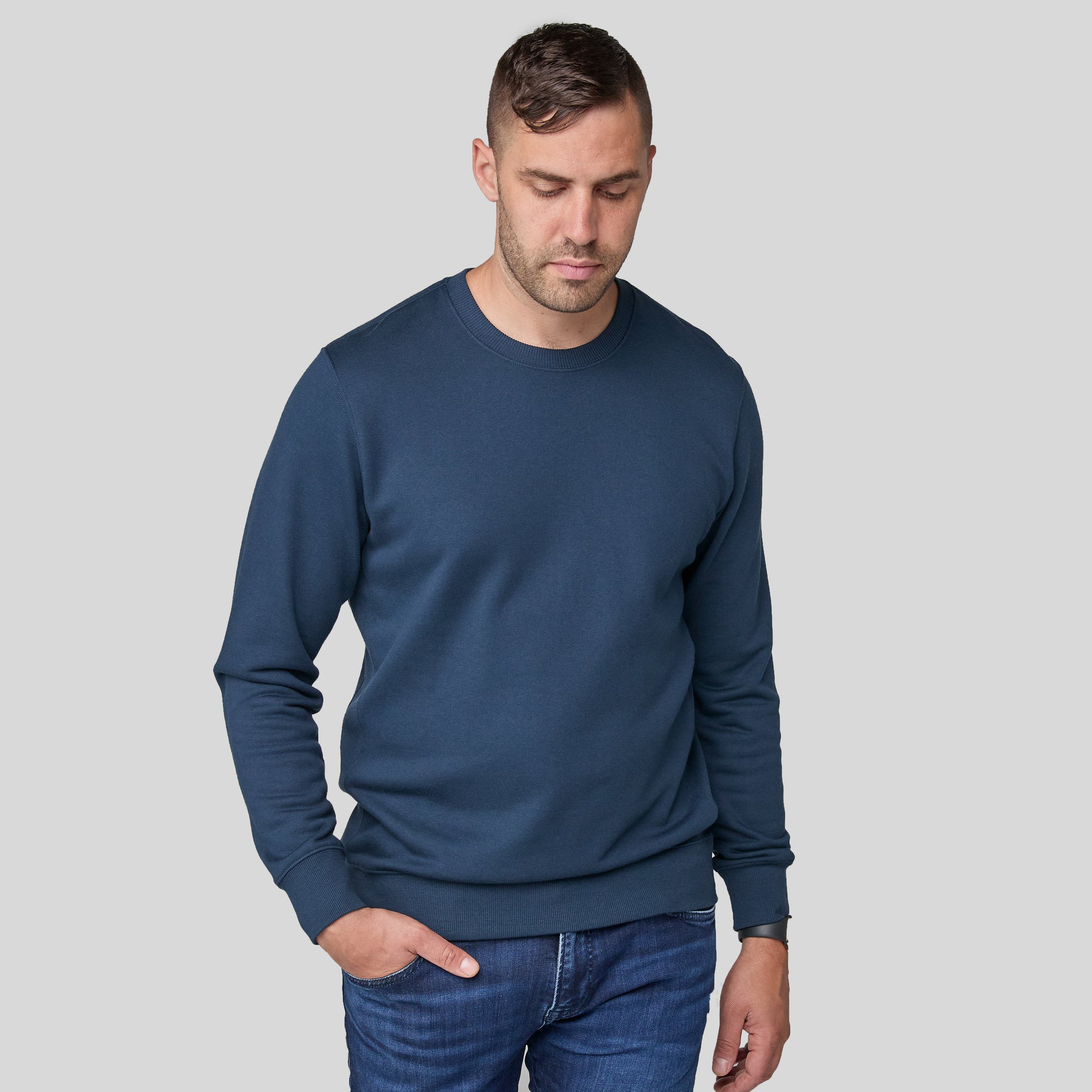 Phil wearing the blue sweater on a gray background